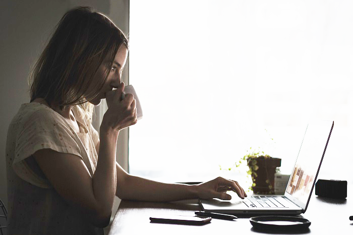 Girl at computer drinking coffee